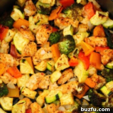 Cooked chicken and veggies in the air fryer basket, perfectly golden and ready to serve.