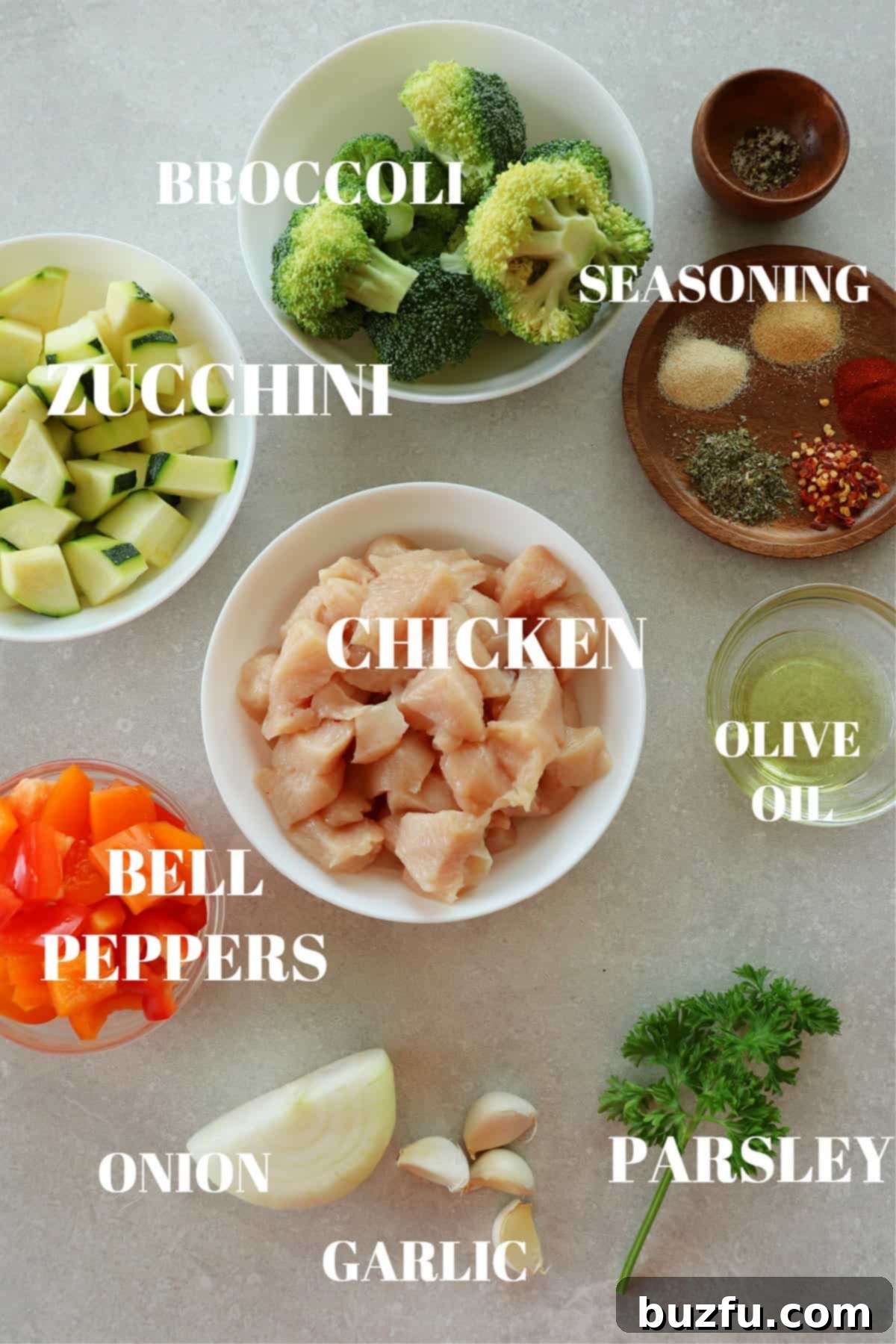 Fresh ingredients for air fryer chicken and vegetables neatly arranged on a gray cutting board.