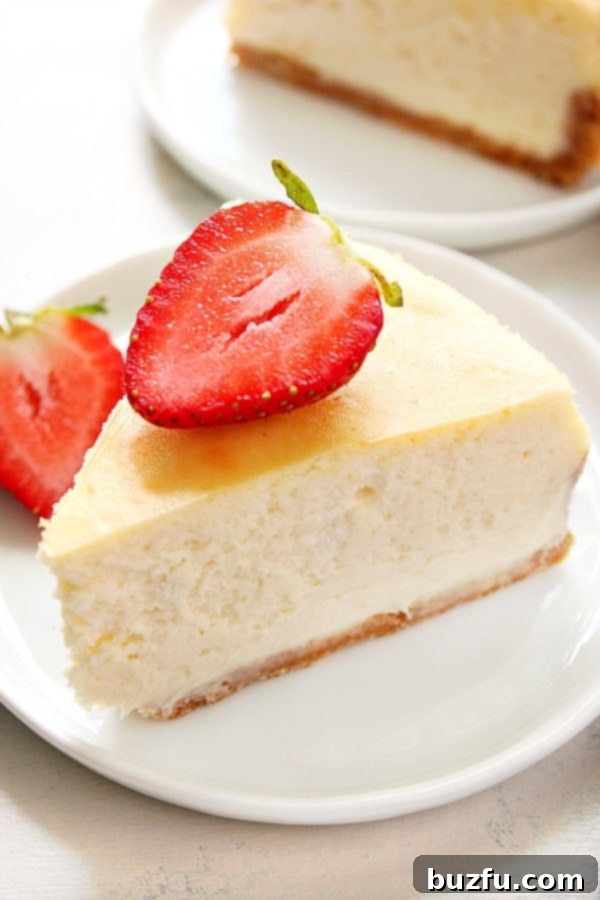 A perfectly sliced piece of cheesecake with a smooth top, served on a small dessert plate.