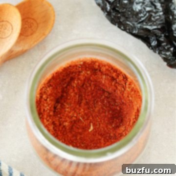 Craft Your Perfect Chili Blend 6 Close up photo of chili seasoning in a glass jar, on a gray board.