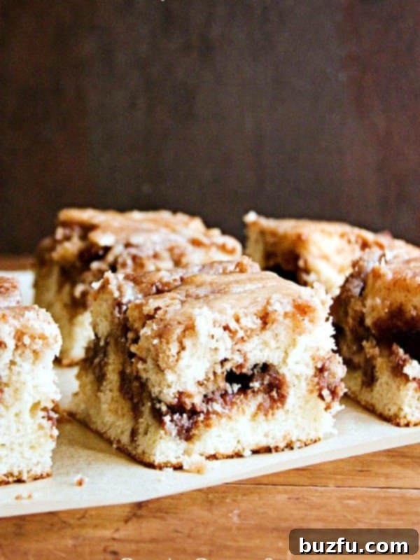 Cake pieces on a parchment paper, showing the moist crumb and cinnamon swirl.