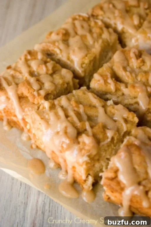A mesmerizing close-up of Caramel Apple Crumb Bars, highlighting the generous, golden crumb topping and a peek at the lush, creamy apple filling beneath.