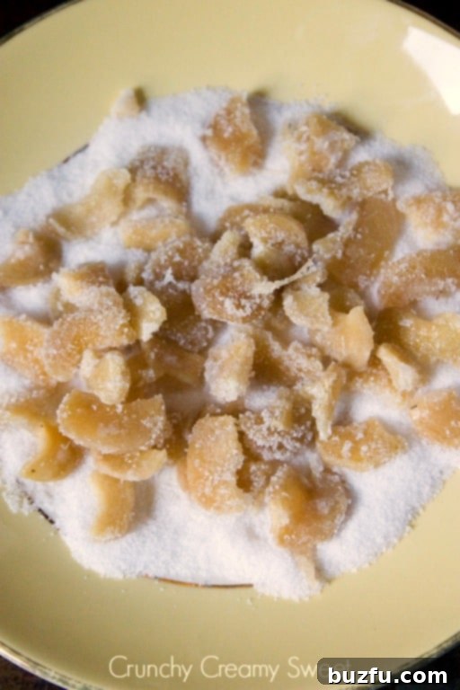 Overhead shot of candied ginger in sugar on plate.