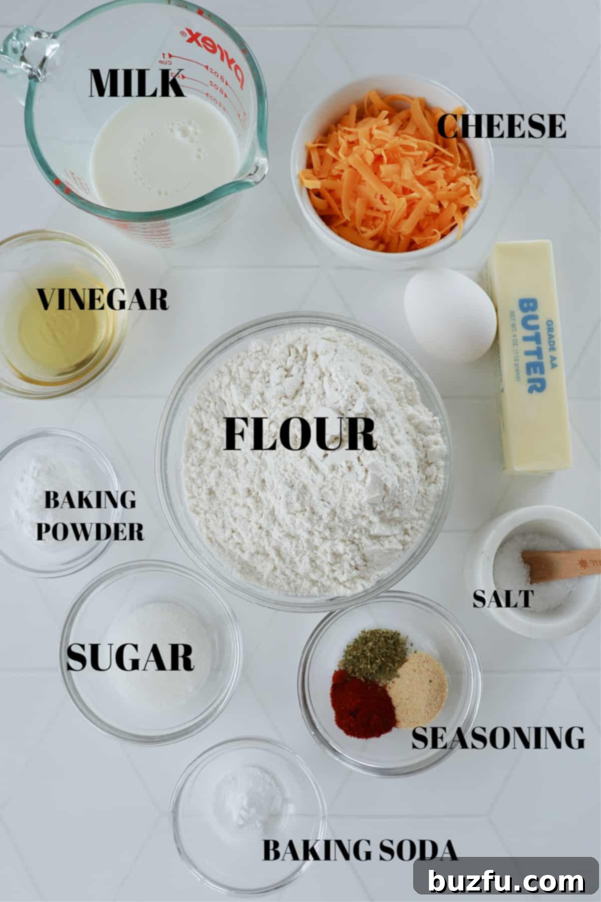 Homestyle Skillet Biscuits 3 Arrangement of biscuit ingredients on a white tile board, including flour, butter, cheese, milk, and spices.