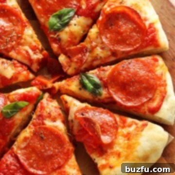 Sliced pizza on a round wooden cutting board.