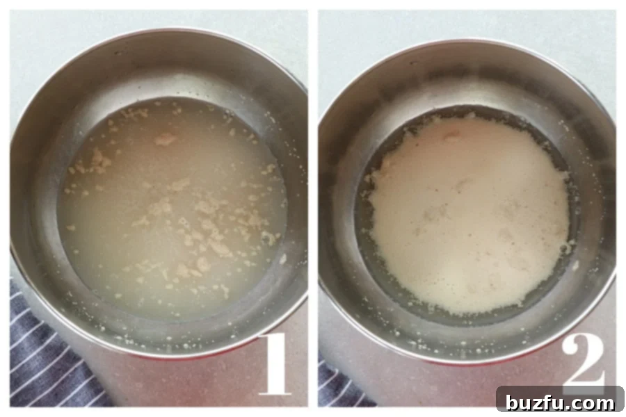Close-up of warm water with sugar and yeast in a mixing bowl, showing the yeast actively foaming on the surface.