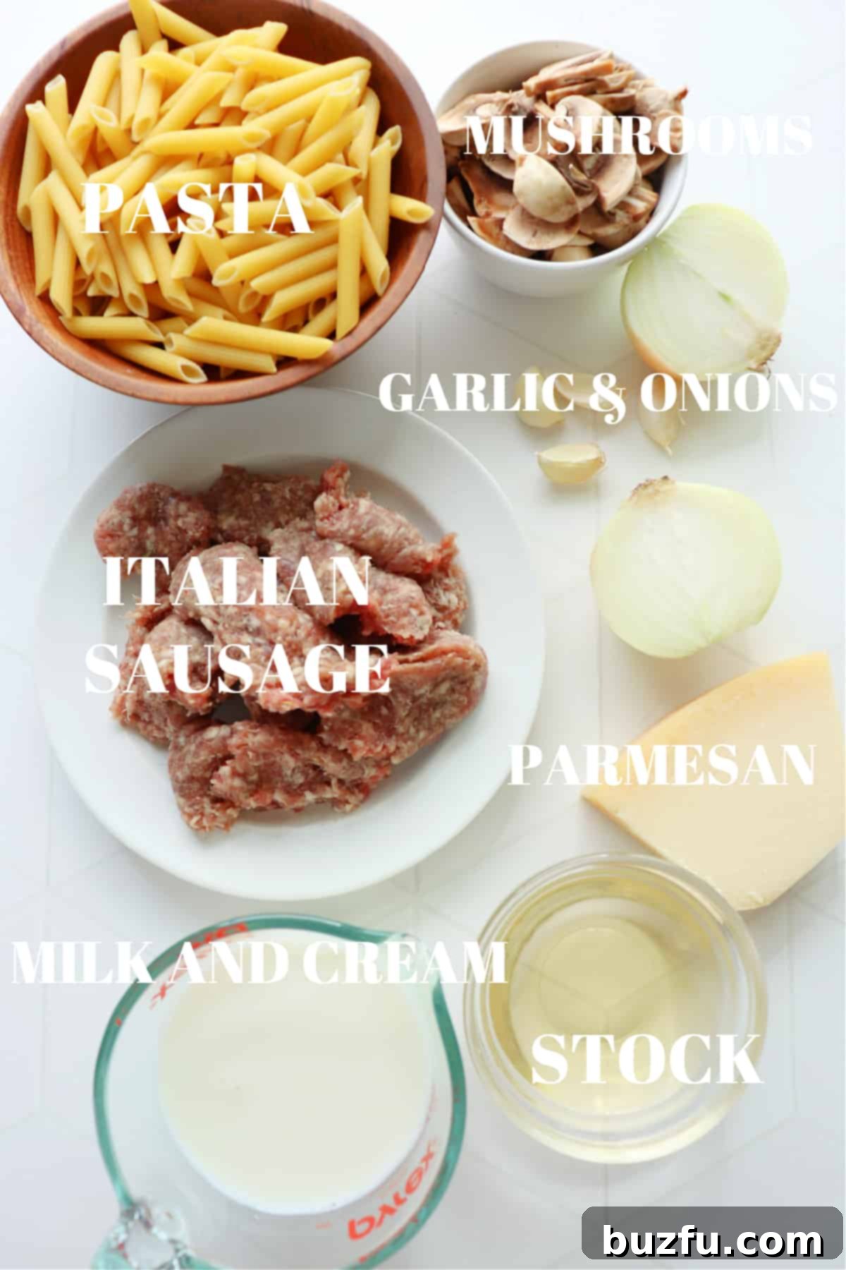 Ingredients for creamy sausage pasta dish on a white tile board.