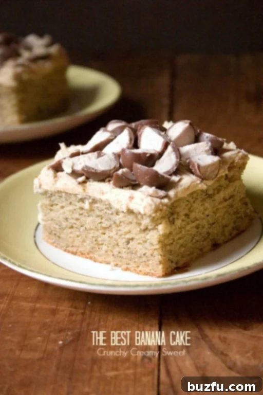 A delectable slice of banana cake topped with crushed Whoppers candy, ready to be enjoyed on a plate.
