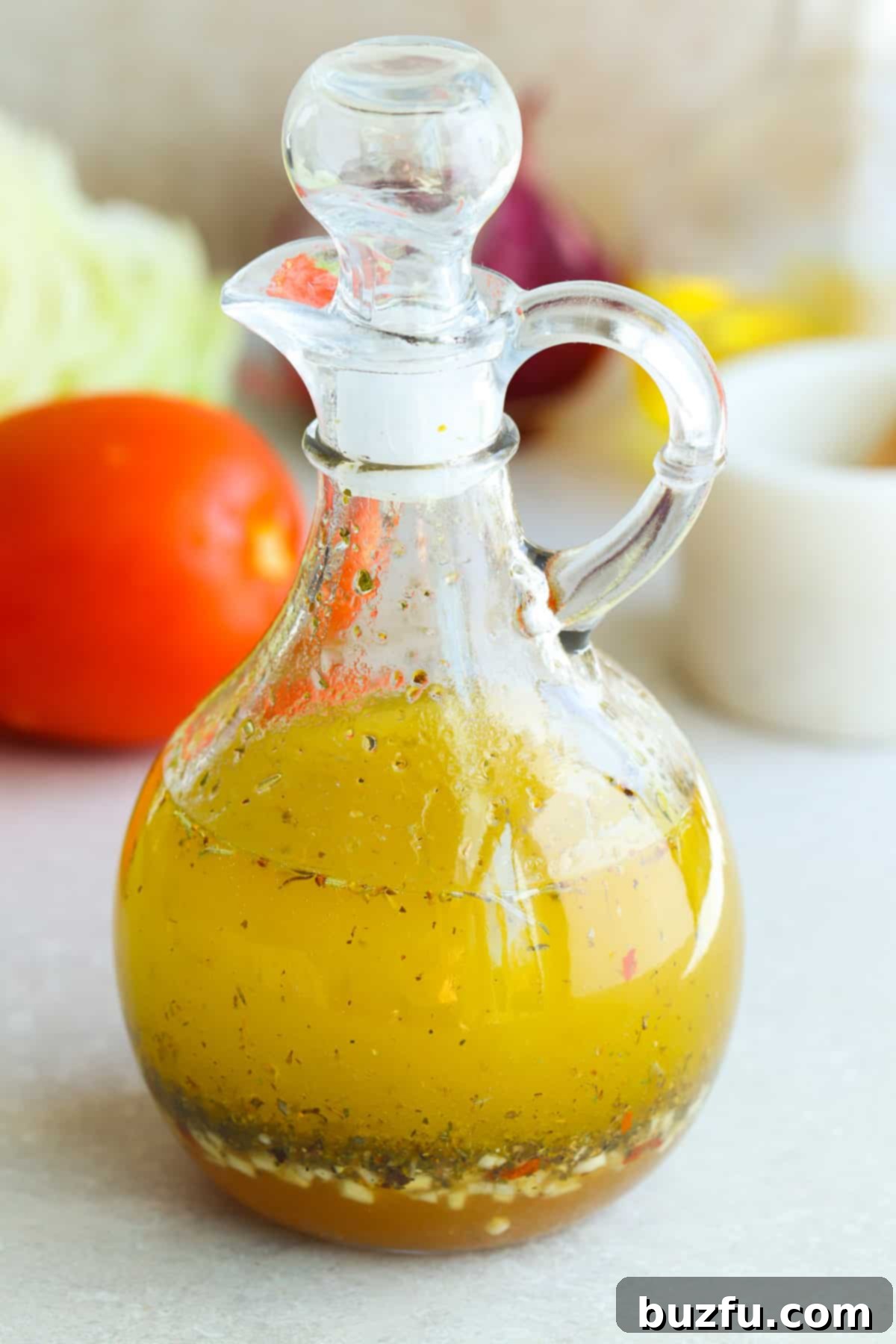 No-Fuss Salad Dressings 3 Italian salad dressing in a glass cruet on a gray board.
