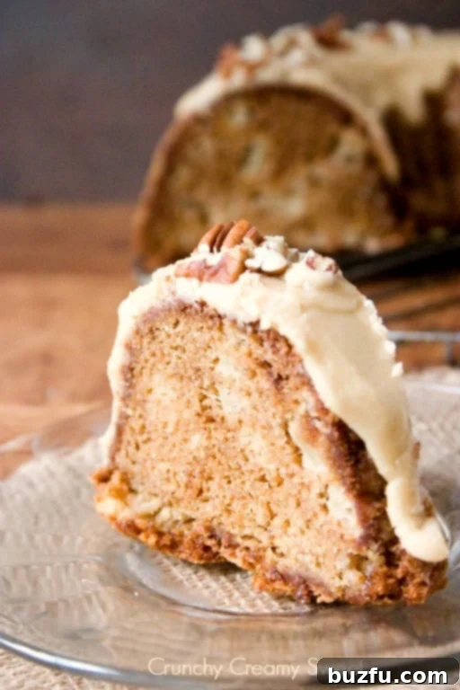 Apple Bundt Cake with Caramel Glaze - melt-in-your-mouth bundt cake with chunks of apples and sweet caramel glaze. Perfect Thanksgiving dessert idea! Slice of apple bundt cake. A perfect cross-section revealing moist cake, tender apple chunks, and the caramel glaze.