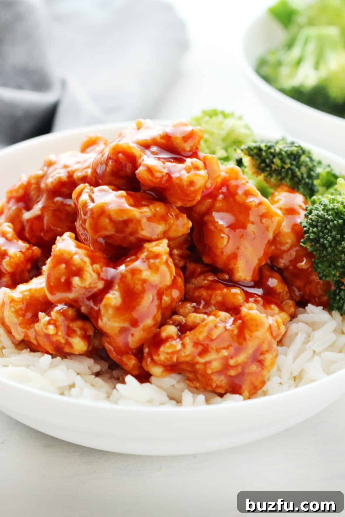 Your Weekly Meal Planner 6 Vibrant Korean chicken served atop a bed of fluffy white rice in a bowl, garnished with sesame seeds and green onions.