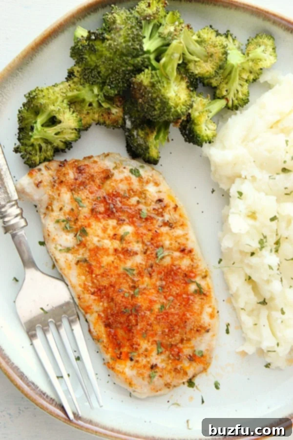 Your Weekly Meal Planner 8 A beautifully arranged dinner plate featuring a juicy baked pork chop, creamy mashed potatoes, and vibrant garlic parmesan roasted broccoli.