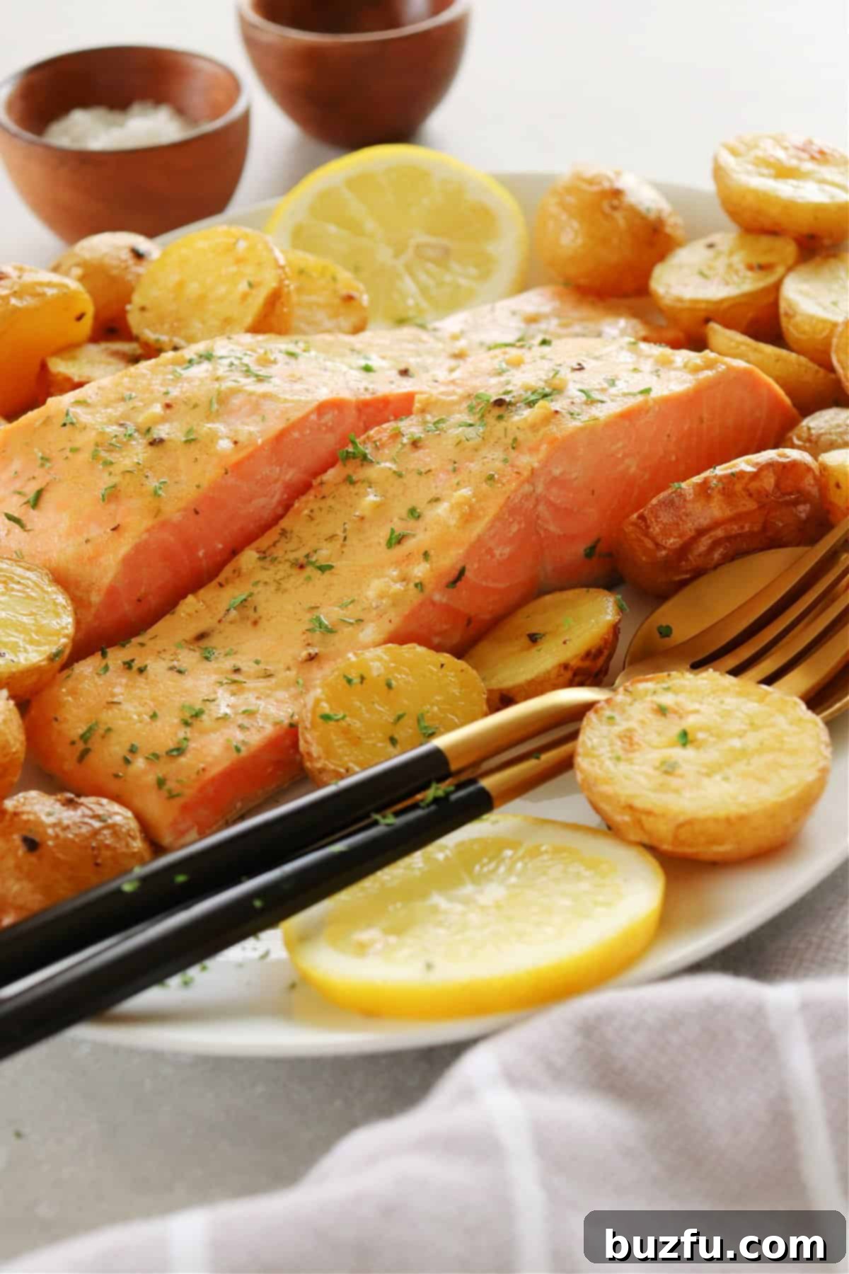 Weekly Meal Plan 3 7 A serving platter holds perfectly baked Dijon salmon fillets alongside roasted golden potatoes, garnished with fresh dill, ready to be enjoyed as a light and elegant meal.