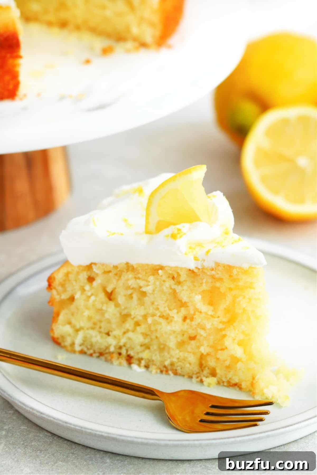 Weekly Meal Plan 3 9 A single, perfectly sliced piece of fluffy lemon cake adorned with a cloud of freshly whipped cream and a delicate lemon slice, served on a elegant dessert plate with a golden fork.