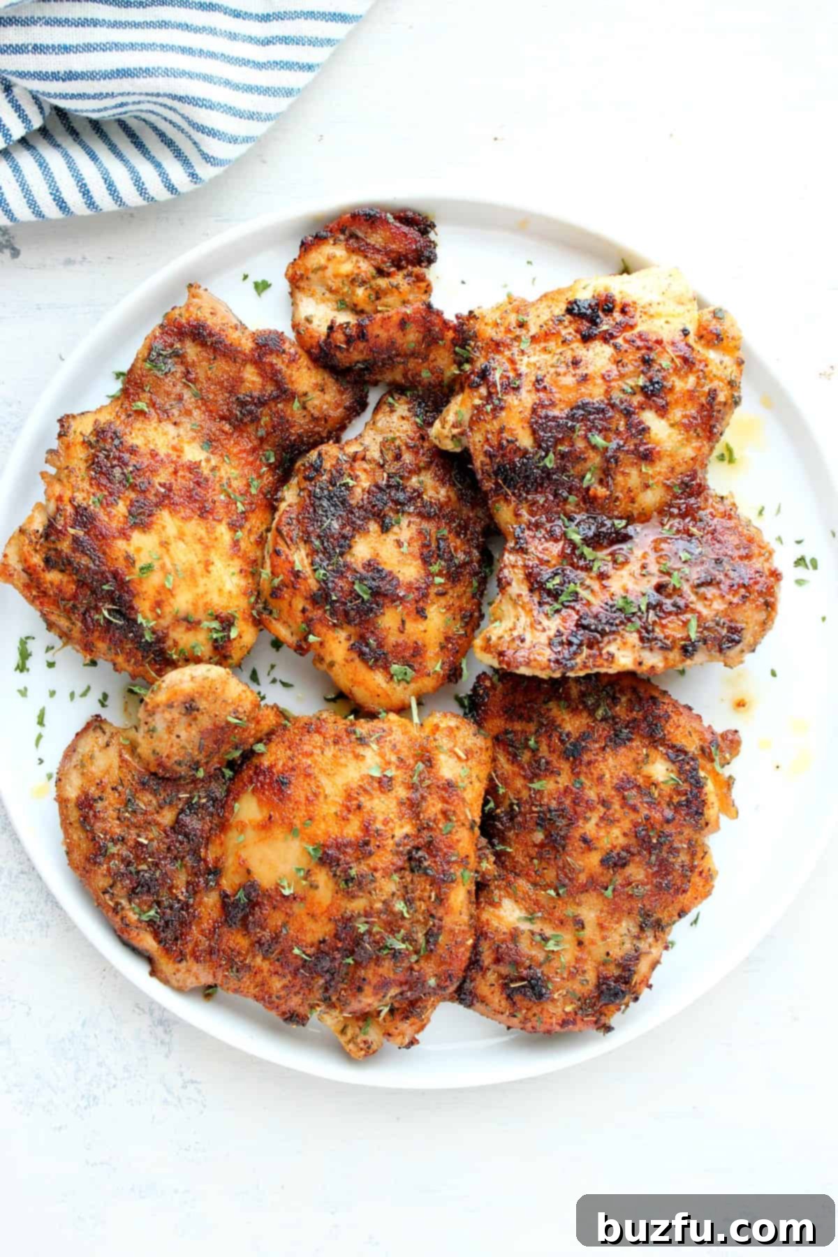 Flavorful Feasts: Week Five 4 Perfectly cooked, golden-brown skillet chicken thighs resting on a clean white plate, ready to be served for an easy weeknight meal.