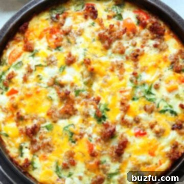 Quiche with potato crust and vegetable and sausage filling, baked in a cast iron casserole dish.
