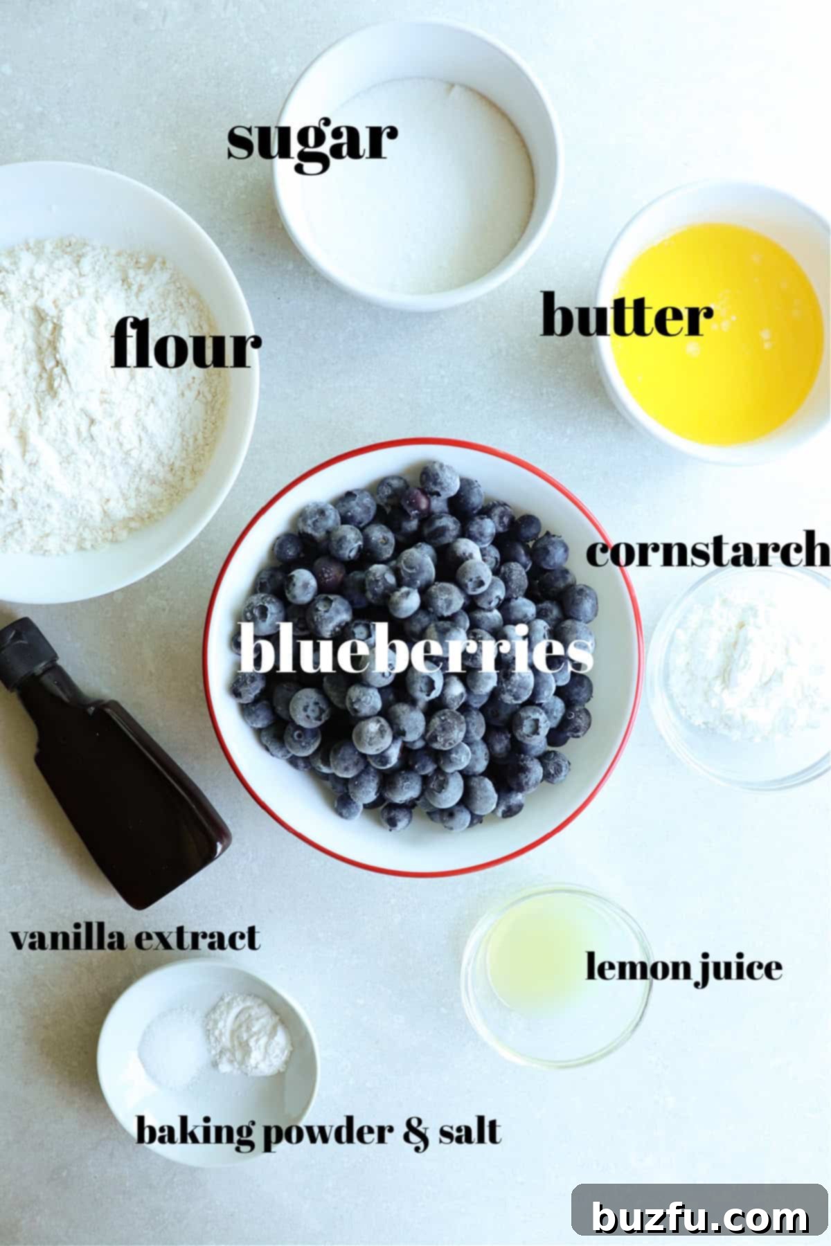 All ingredients for blueberry crumble in bowls, on a gray background.