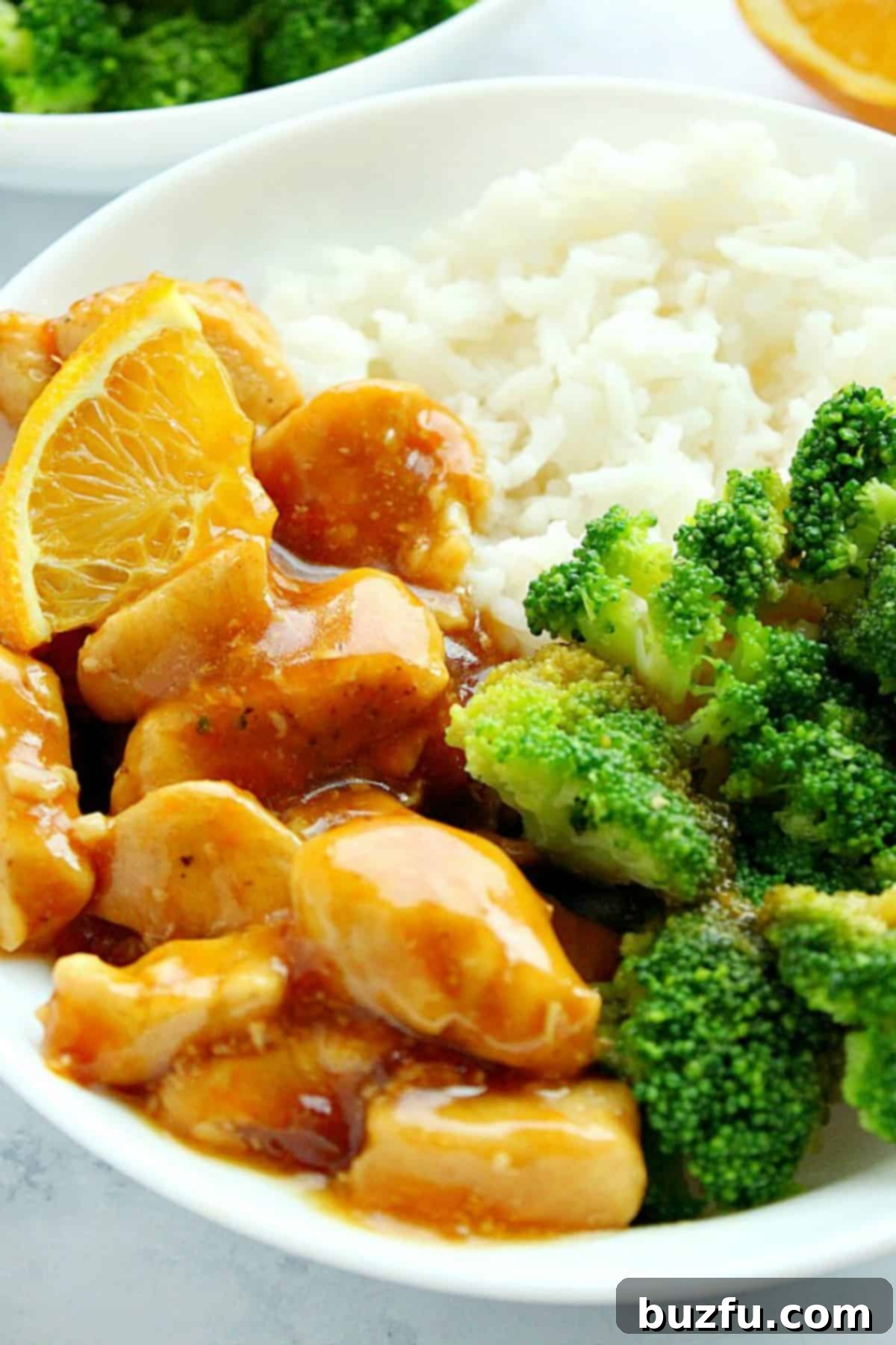 Delectable Orange Chicken served with fluffy white rice and vibrant green steamed broccoli on a plate.