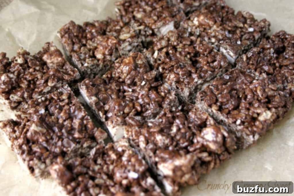 Dark Chocolate and Sea Salt Krispies Treats sliced into bars on a wooden surface.