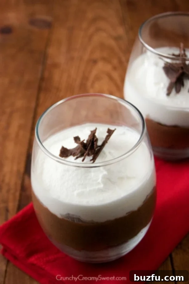 Decadent Chocolate Trifle For Two, layered with rum-infused chocolate cake, chocolate mousse, and whipped cream, presented in elegant serving glasses.