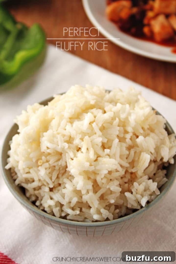 Side shot of cooked rice in a gray bowl, garnished with a sprig of fresh herb.