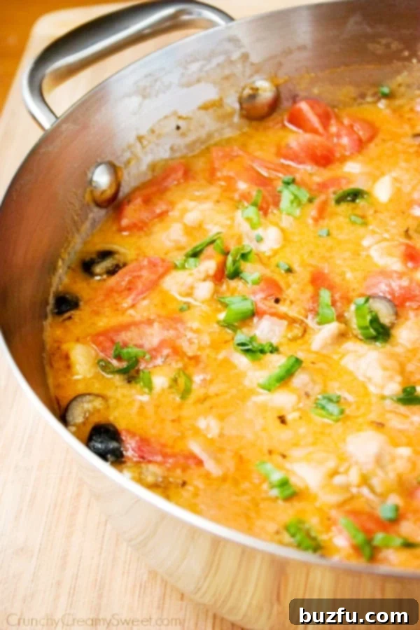 Chicken Marengo in a skillet, garnished with fresh herbs.