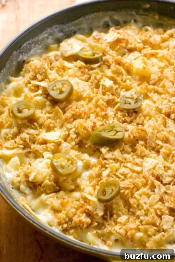Pepper Jack Mac and Cheese in a skillet, garnished with fresh jalapenos and red pepper flakes, ready to be served.