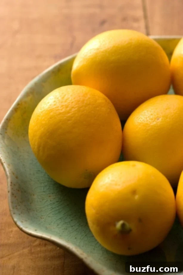 Bright yellow Meyer lemons on a rustic wooden surface.