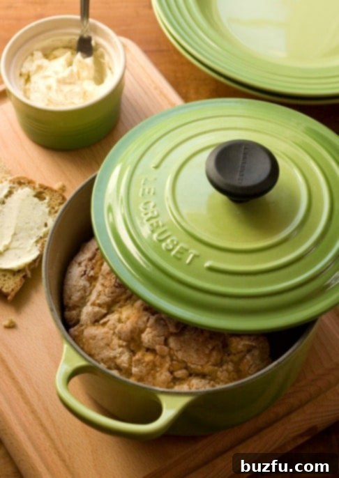 Garlic and Herb Irish Soda Bread with Lemon Honey Butter - fragrant and flavorful soda bread with easy whipped butter. Side shot of soda bread in covered cast iron pot.