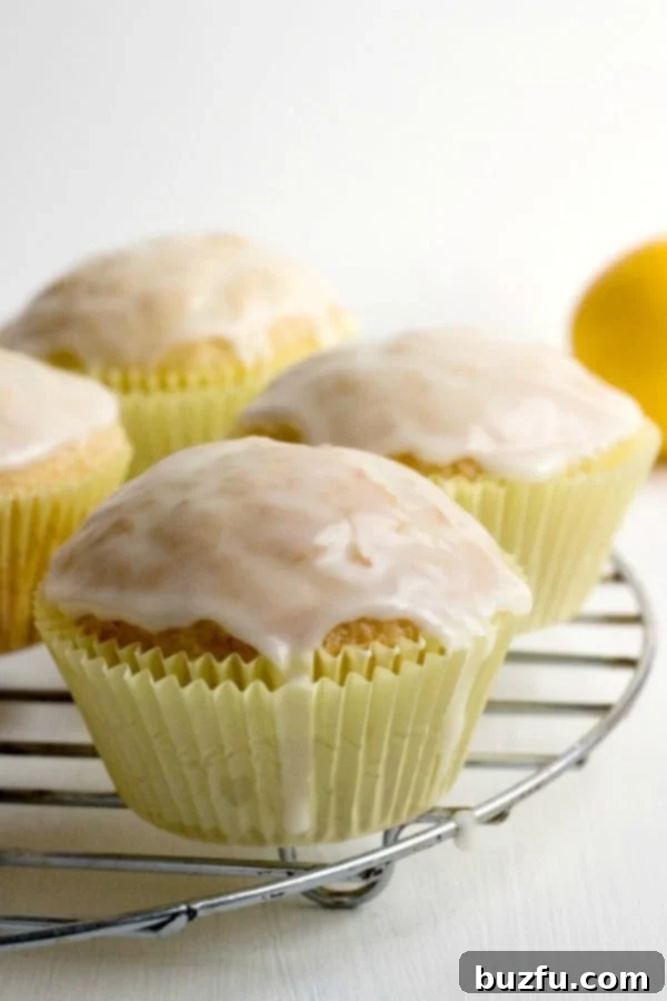 Freshly baked Glazed Lemon Muffins cooling on a wire rack, ready for their sweet lemon glaze.