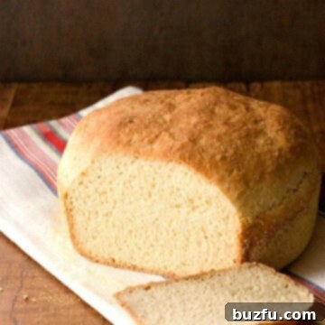 English Muffin Bread on kitchen towel, with one slice cut.