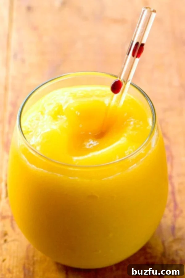 Tropical Mango Margarita Slushy 2 Close-up of Mango Margarita Slush in a fancy glass with a straw.