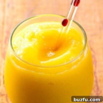 Tropical Mango Margarita Slushy 3 Mango Margarita Slush ready to serve in a tall glass.