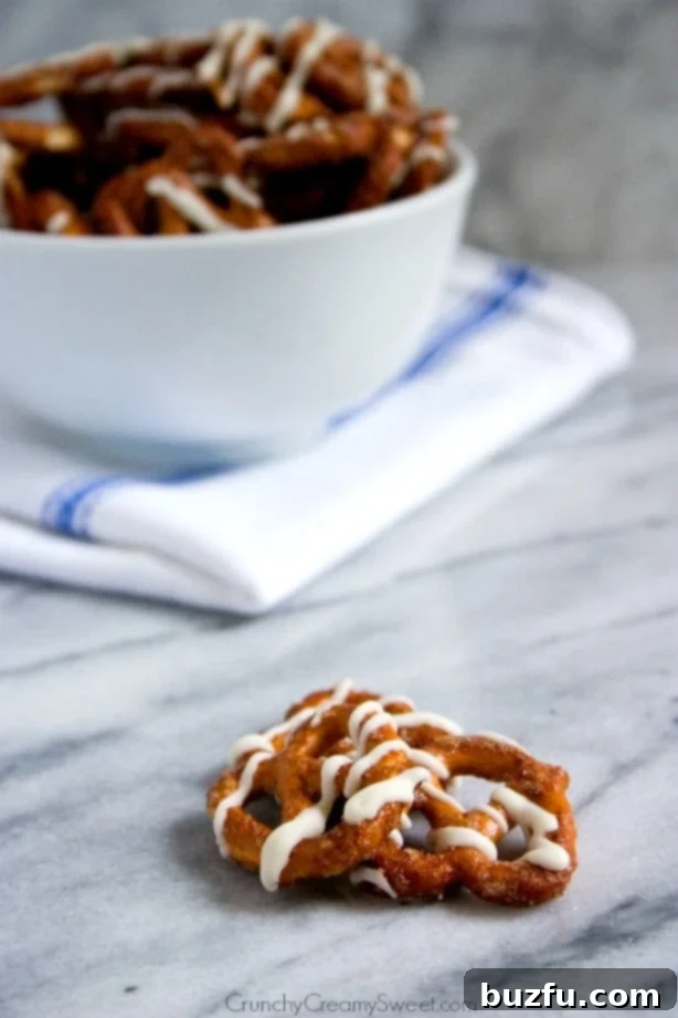 Cinnamon Roll Pretzels - close up of cinnamon sugar coated pretzels baked and drizzled with white chocolate, showing texture.