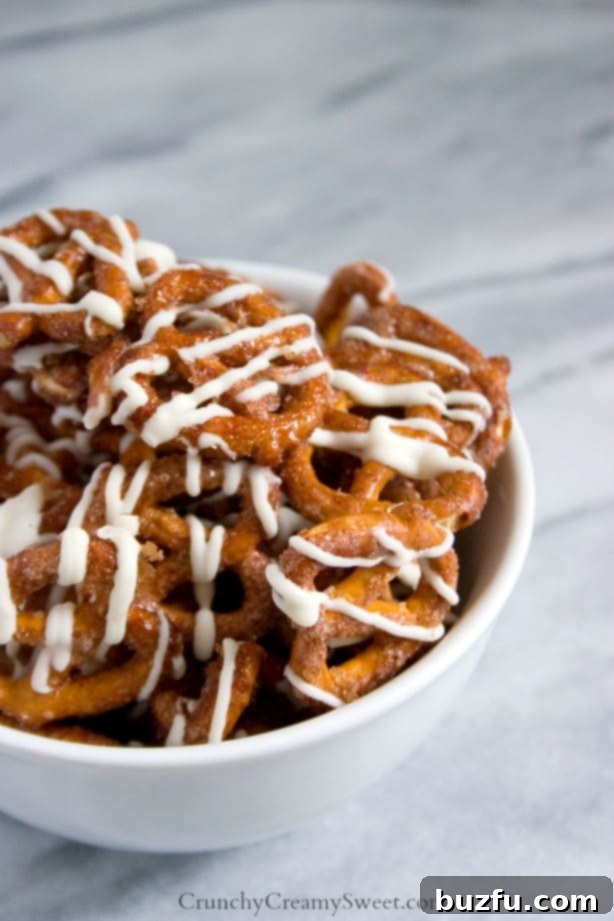 Cinnamon Roll Pretzels - easy and delicious snack idea in a bowl with a hand reaching for one