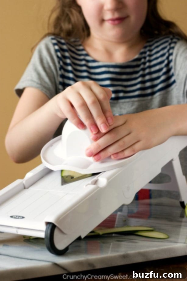 Creamy Garlic Mushroom Zucchini Noodles Little Chefs Can Make 4 A child actively making zucchini noodles with a spiralizer