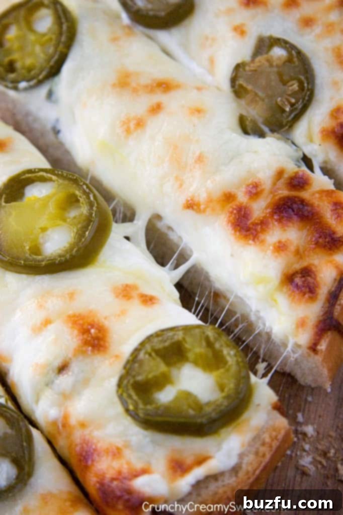 Jalapeno Popper Cheesy Garlic Bread - the perfect game day food, served on a wooden board with a festive background