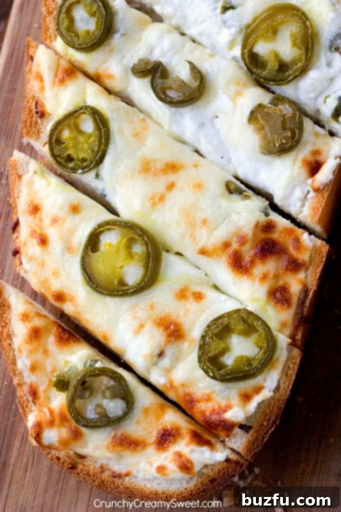 Cheesy Garlic Bread with Jalapeno Popper Dip Topping, showcasing gooey cheese and sliced jalapenos