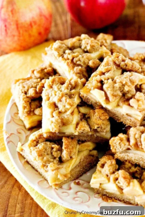 Golden brown Apple Pie Bars arranged artfully on a white plate, showcasing their inviting texture and delicious appeal.