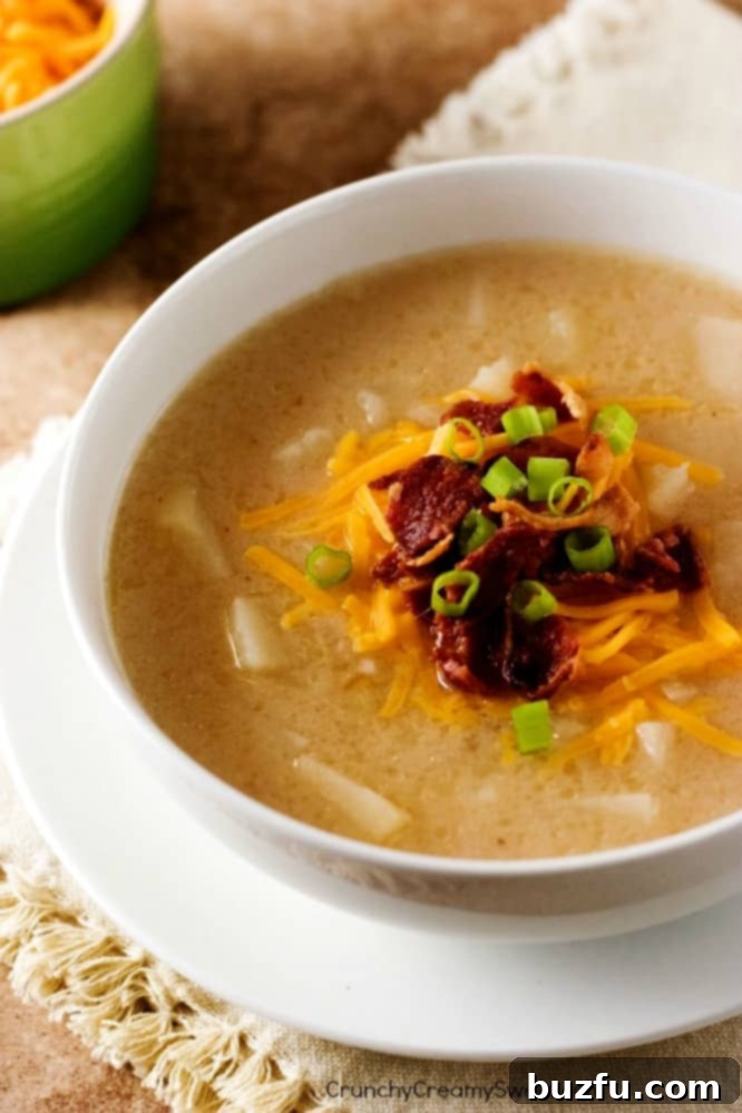 Delicious Slow Cooker Baked Potato Soup topped with crispy bacon