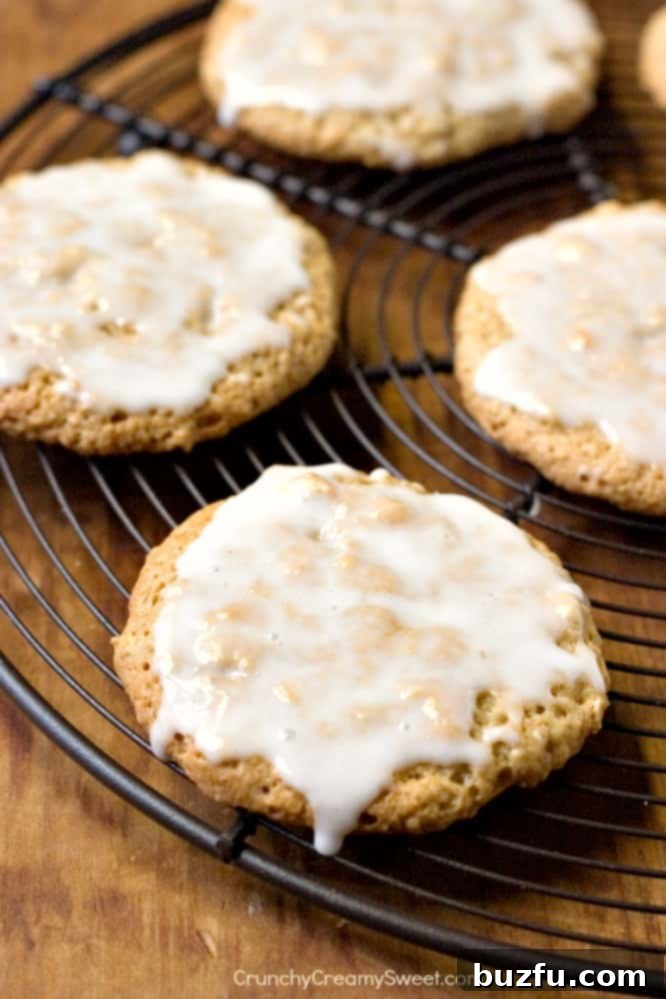Old-Fashioned Iced Oatmeal Cookies - A close-up of a stack of golden brown oatmeal cookies with a smooth white glaze.