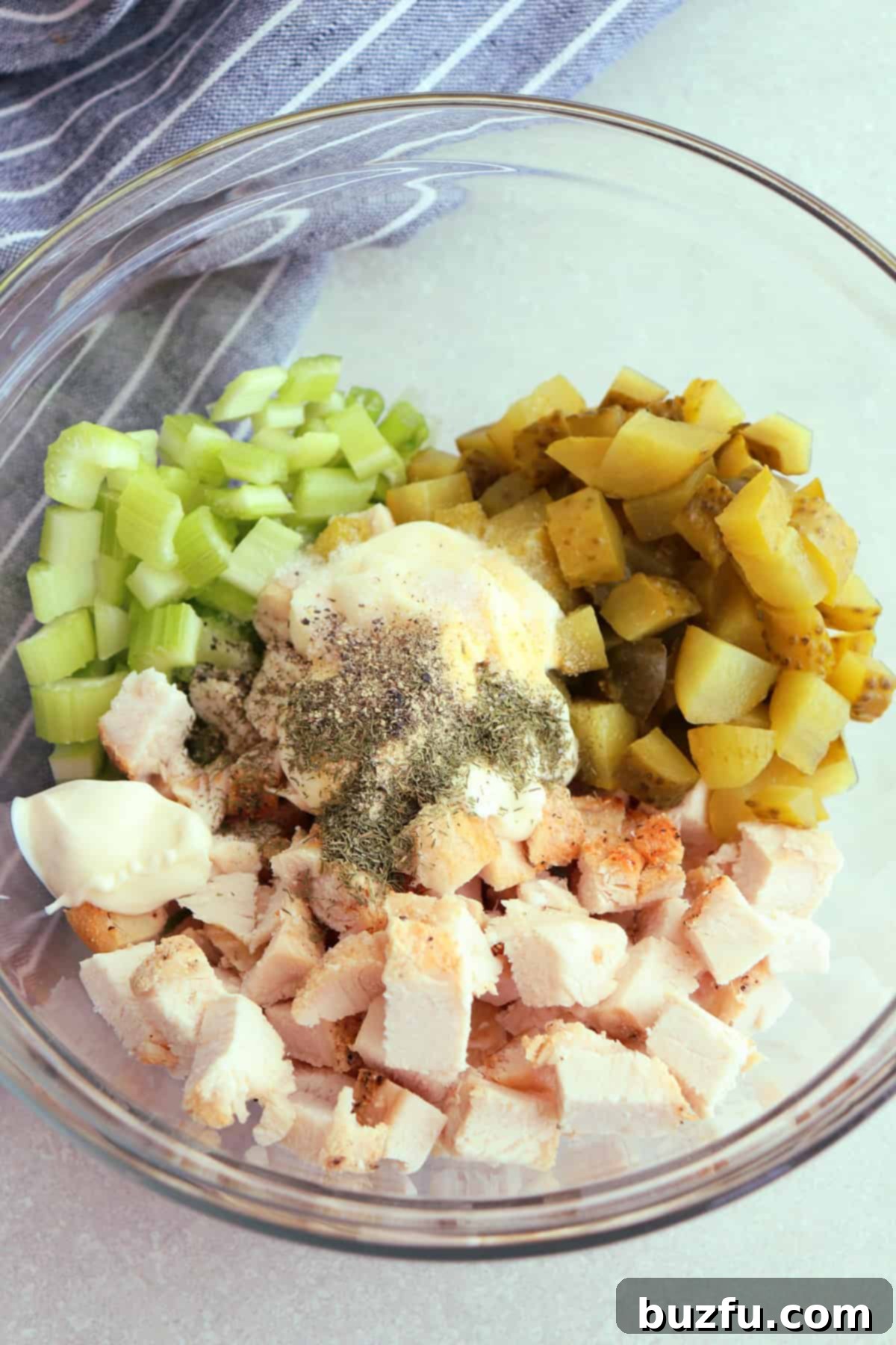 Dill Pickle Chicken Salad Delight 4 Chicken, pickles, celery, green onion, mayo, and spices in a glass mixing bowl.